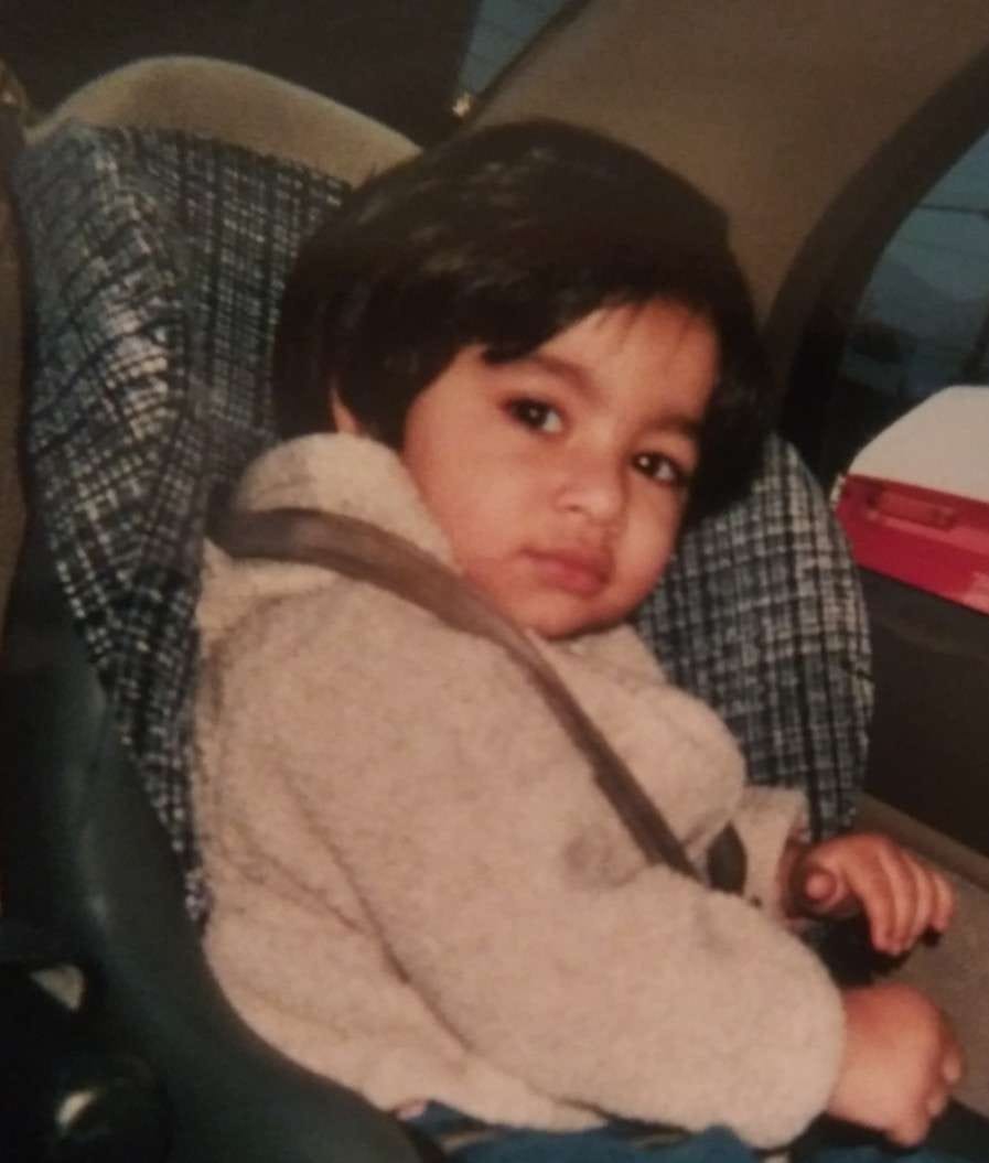 young girl in a carseat looking slightly judgemental
